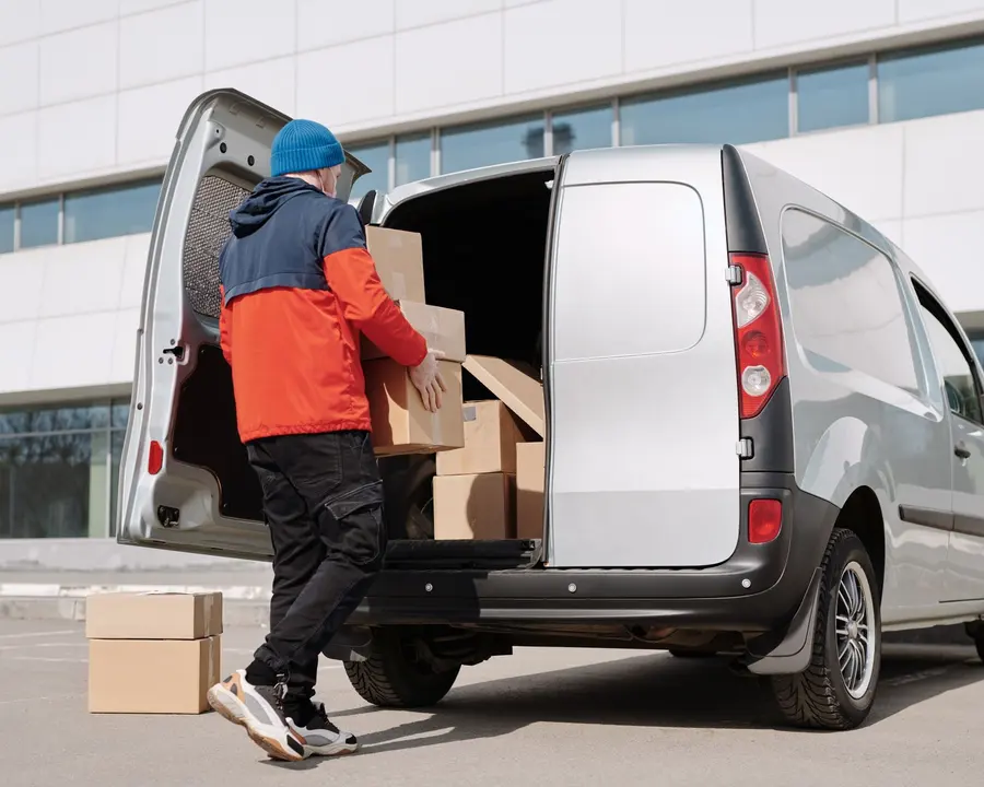 Kleinerer Transport wird in ein Fahrzeug verladen